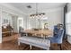 Dining room features a farmhouse table with tufted bench, chandelier, and view into the kitchen and formal sitting area at 350 Medridge Dr, Johns Creek, GA 30022