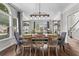 Dining room with rustic table, modern chairs, chandelier, and natural light, with shelving adding architectural detail at 350 Medridge Dr, Johns Creek, GA 30022