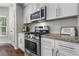 Well-lit kitchen features stainless steel appliances, light countertops, white cabinets, and view to the outside at 350 Medridge Dr, Johns Creek, GA 30022