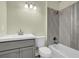 Modern bathroom features a gray vanity, white toilet, and gray and white tiled shower and bathtub at 3571 Kennesaw Station Nw Dr, Kennesaw, GA 30144
