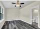 Bright bedroom features gray wood flooring, neutral walls, white trim, a ceiling fan, and an ensuite bathroom at 3571 Kennesaw Station Nw Dr, Kennesaw, GA 30144