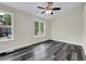 Bright bedroom features gray wood flooring, neutral walls, white trim, and two large windows at 3571 Kennesaw Station Nw Dr, Kennesaw, GA 30144