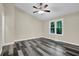 Bright bedroom features gray wood flooring, neutral walls, white trim, a ceiling fan, and a backyard view from the window at 3571 Kennesaw Station Nw Dr, Kennesaw, GA 30144