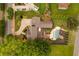 Aerial view of a sprawling home with a well-manicured lawn, pool, patio and putting green, surrounded by lush landscaping at 525 E Main St, Buford, GA 30518