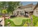 Extensive backyard with patio, putting green, mature trees, and well-manicured landscaping is ideal for entertaining at 525 E Main St, Buford, GA 30518