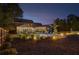 Backyard with an in-ground pool, a patio with lounge seating, a well-manicured lawn and landscape lighting at dusk at 525 E Main St, Buford, GA 30518