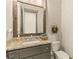 Charming powder room with rustic wood mirror frame, granite countertop, and classic toilet at 525 E Main St, Buford, GA 30518