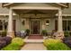 Inviting front porch with porch swing, rocking chair, and decorative rug and wall hangings at 525 E Main St, Buford, GA 30518