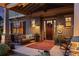 Inviting front porch with porch swing, rocking chair, and decorative rug and wall hangings at dusk at 525 E Main St, Buford, GA 30518