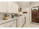 Well-organized laundry room with white cabinetry, granite countertops, and a front-loading washer and dryer at 525 E Main St, Buford, GA 30518