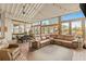 Cozy living room featuring a large sectional couch, brick floors, and abundant natural light from surrounding windows at 525 E Main St, Buford, GA 30518