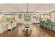Open concept living space with dining table, kitchen island, hardwood floors and oversized windows at 525 E Main St, Buford, GA 30518