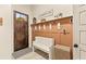 Mudroom with a coat rack, storage basket, white bench, and decorative elements, conveniently located by the front door at 525 E Main St, Buford, GA 30518