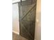Modern farmhouse gray barn door with black hardware accents at 6914 N Baggett Rd, Douglasville, GA 30134
