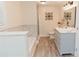 Bright bathroom featuring gray vanity with granite countertop, bathtub, and decorative accents at 6914 N Baggett Rd, Douglasville, GA 30134