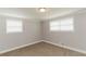A simple bedroom features neutral walls, plush carpet, and natural light from two windows at 6914 N Baggett Rd, Douglasville, GA 30134
