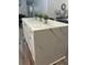 Kitchen island showcasing quartz countertop with white cabinets and decorative plants at 6914 N Baggett Rd, Douglasville, GA 30134