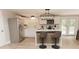 Well-lit kitchen features white cabinetry, stainless steel appliances, island with seating and a view to the backyard at 6914 N Baggett Rd, Douglasville, GA 30134
