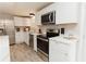 Modern kitchen features white cabinetry, stainless steel appliances, and quartz countertops with stylish fixtures at 6914 N Baggett Rd, Douglasville, GA 30134