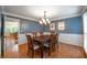 Dining room with hardwood floors, wainscoting detail, and a view into a bright adjoining room at 1590 Greyson Rdg, Marietta, GA 30062