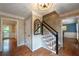Inviting foyer with hardwood floors, staircase with black handrail, and views into adjoining rooms at 1590 Greyson Rdg, Marietta, GA 30062