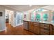Bright kitchen with wooden floors, cabinets, granite countertops, stainless steel appliances, and a vaulted ceiling with large windows at 1590 Greyson Rdg, Marietta, GA 30062