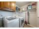 Functional laundry room equipped with modern washer and dryer, storage cabinets, and shelving at 1590 Greyson Rdg, Marietta, GA 30062