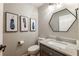 Stylish half-bathroom features hexagon mirror, modern vanity, and unique feather prints at 1590 Greyson Rdg, Marietta, GA 30062