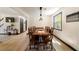 Dining area featuring wood-look flooring, a long wooden table with chairs, and modern lighting fixtures at 165 Colony Cir, Canton, GA 30114