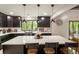 Modern kitchen with granite countertops, black cabinets, and a window overlooking the backyard at 165 Colony Cir, Canton, GA 30114