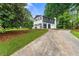 Rear view of two-story home with attached garage and spacious driveway at 2702 Galaxy Ct, Decatur, GA 30034