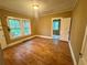 Sunlit bedroom with hardwood floors, two windows offering natural light, and neutral walls at 3366 College St, College Park, GA 30337