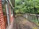 Weathered wooden deck with wood railing, accessible through a glass door, offering an outdoor space at 3366 College St, College Park, GA 30337