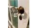 Close-up of an antique glass doorknob on a vintage door with a tarnished brass lock plate at 3366 College St, College Park, GA 30337