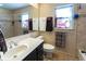 Neutral bathroom with decorative mirror, tile backsplash, and updated fixtures at 1830 Brandy Se Ln, Conyers, GA 30013