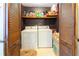 Bright laundry room features full size washer and dryer, shelving, and shutter doors at 1830 Brandy Se Ln, Conyers, GA 30013