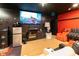 Cozy living room features a television, speakers, compact refrigerator and orange and black furnishings at 1830 Brandy Se Ln, Conyers, GA 30013