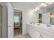 Bathroom with double sink vanity, modern lighting, and doorway view into the bedroom at 295 Cranston Dr, Canton, GA 30114