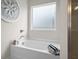 Bathroom showcasing a pristine white bathtub, frosted window, and decorative wall art at 295 Cranston Dr, Canton, GA 30114