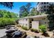 Apartment building with well-maintained landscaping and ample parking, nestled among mature trees at 311 Peachtree Hills Ne Ave # 10C, Atlanta, GA 30305