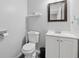 Cozy half bathroom with white vanity, framed mirror, and toilet in a neutral color palette at 6034 Farmwood Se Way, Mableton, GA 30126