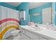 Colorful bathroom features a single sink, toilet, and shower with a rainbow shower curtain at 6034 Farmwood Se Way, Mableton, GA 30126