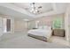 Large main bedroom boasts a tray ceiling, carpet, and ample space for relaxation at 6034 Farmwood Se Way, Mableton, GA 30126