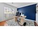 Bright home office featuring a large window, modern desk, and a bold accent wall at 6034 Farmwood Se Way, Mableton, GA 30126