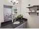 This cozy bathroom offers a vanity with granite countertops and decorative shelves at 1384 Sunrise Way, Lawrenceville, GA 30046