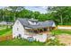 Rear exterior view of a home with a covered patio, spacious yard, and lush greenery at 1384 Sunrise Way, Lawrenceville, GA 30046