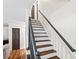 The home's staircase is painted white with wooden treads and has a black railing at 1384 Sunrise Way, Lawrenceville, GA 30046