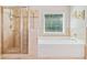Bathroom featuring a tiled shower, a soaking tub, and neutral-toned tile flooring at 3230 Sundew Nw Dr, Acworth, GA 30101