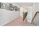 Upstairs hallway with carpet flooring, wooden banister, and decorative picture frames on the adjacent wall at 3230 Sundew Nw Dr, Acworth, GA 30101