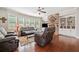Cozy living room featuring a stone fireplace, hardwood floors, and lots of natural light from large windows at 3230 Sundew Nw Dr, Acworth, GA 30101